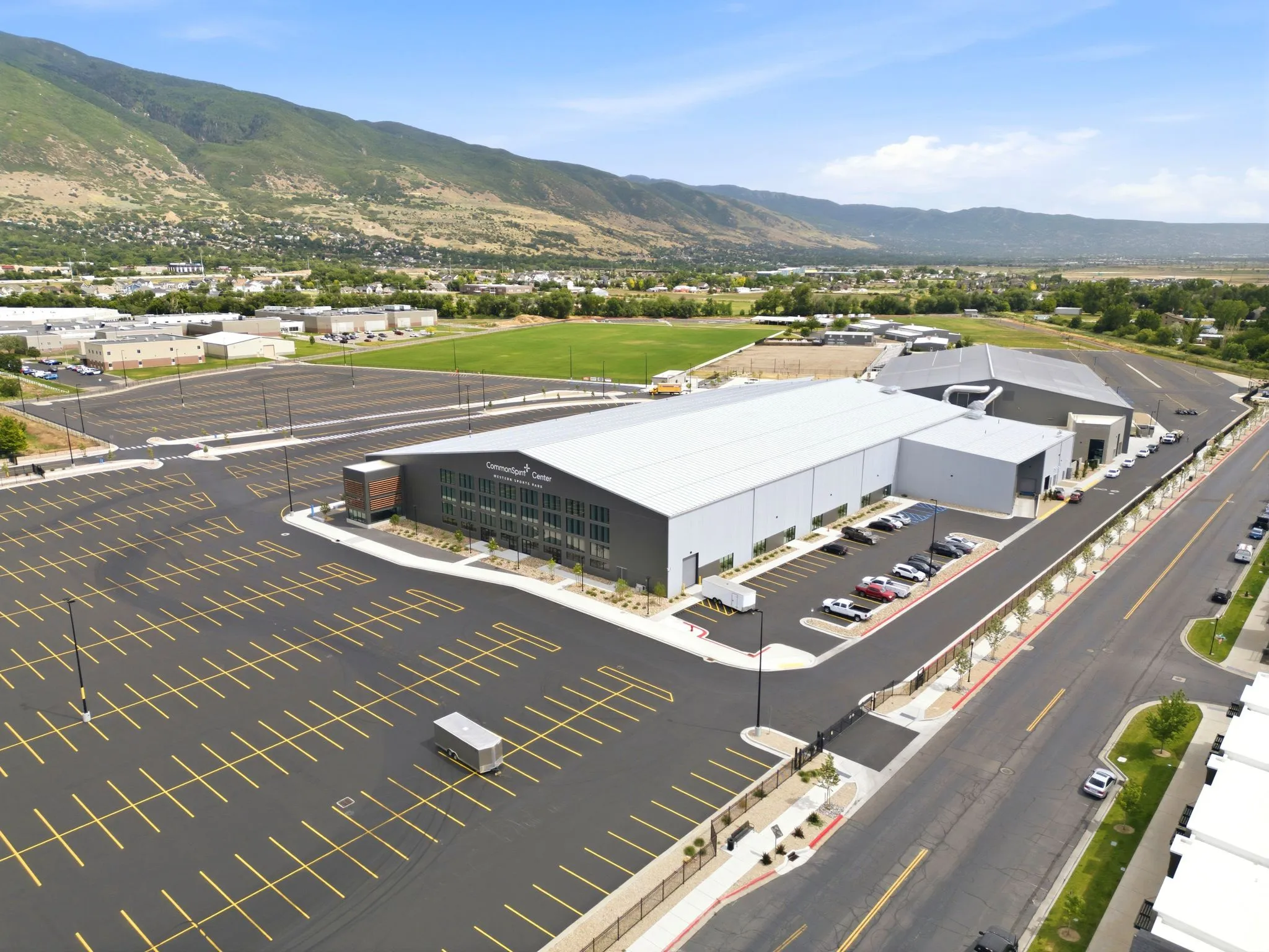 Modern commercial building featuring extensive paved parking, a large lot, and a prominent facade with multiple windows