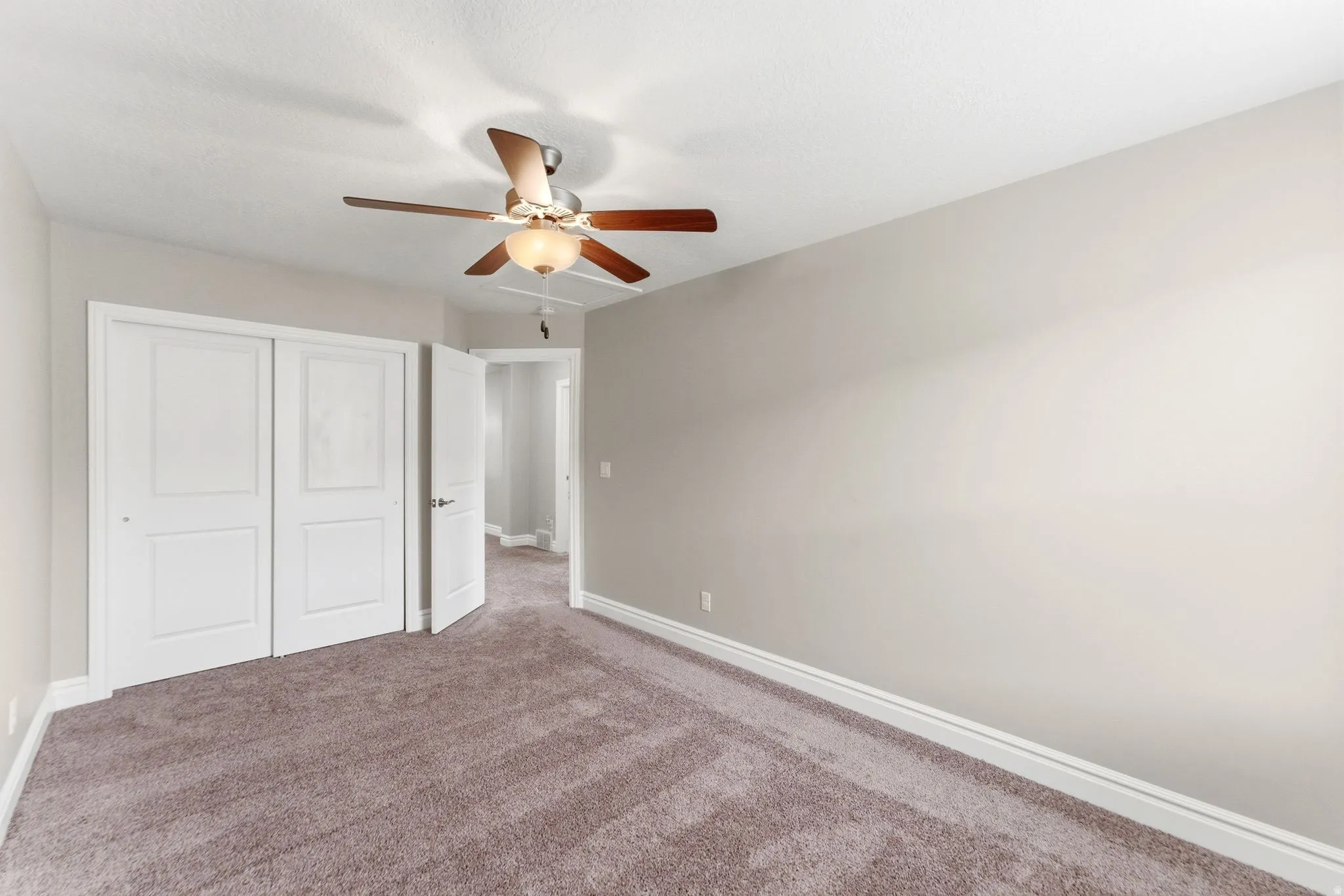 Carpeted interior room with neutral wall tones