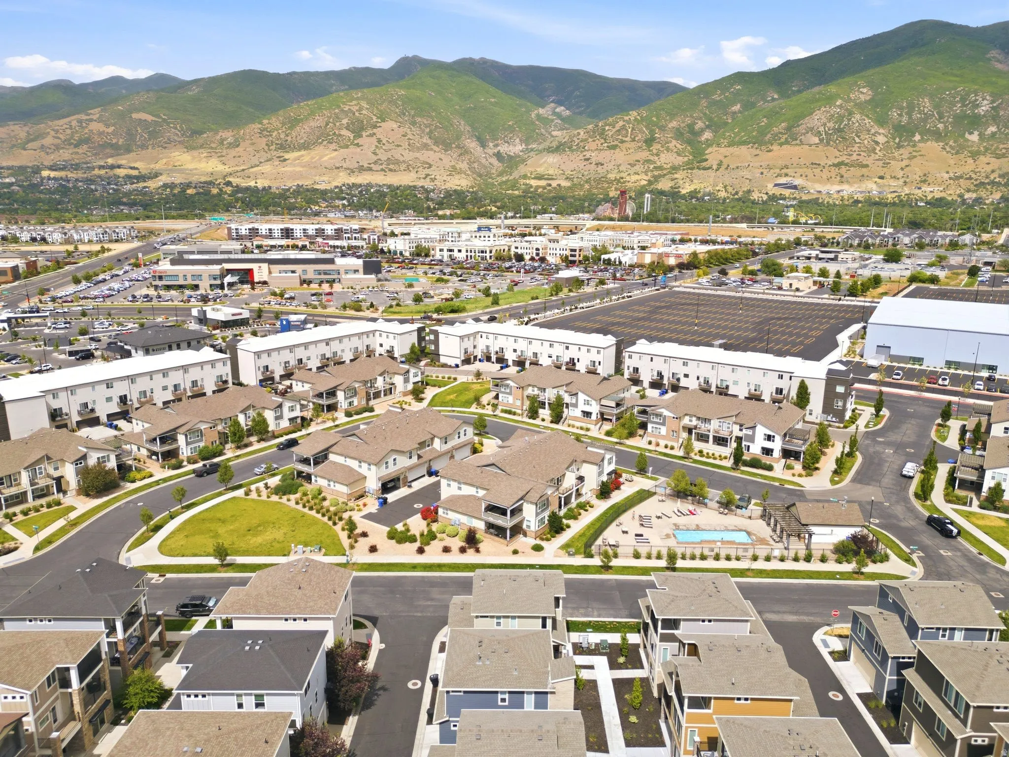 Aerial perspective showcasing a community with residential buildings and mountain backdrop