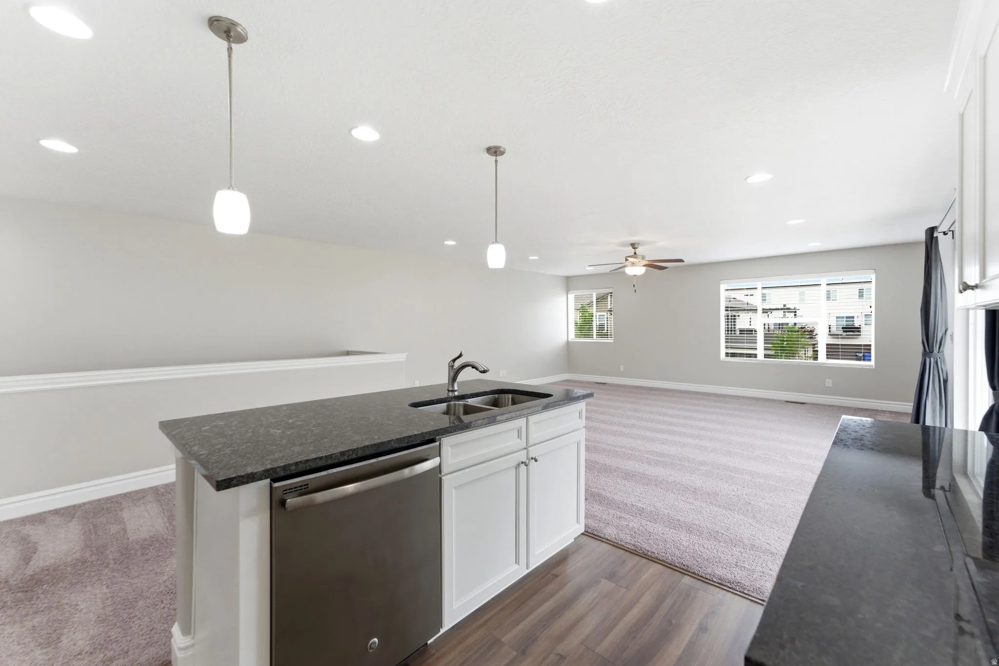 Kitchen island featuring a stainless steel dishwasher and undermount sink
