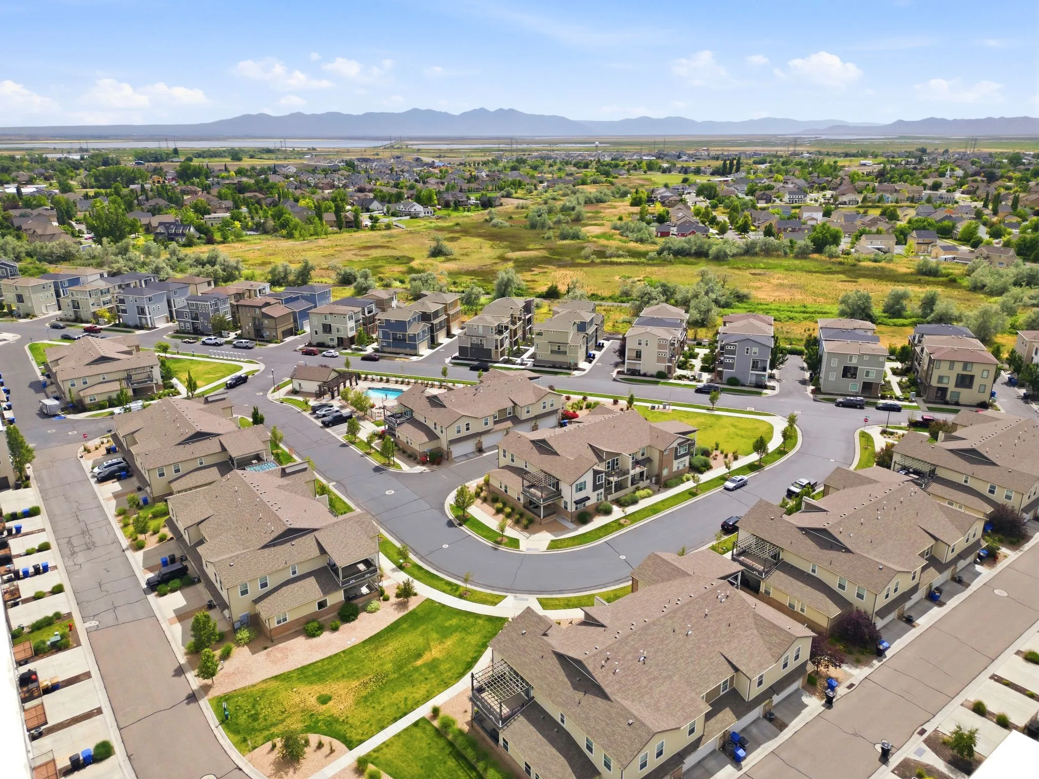 Aerial view of a residential community featuring varied architectural styles and a mountain backdrop