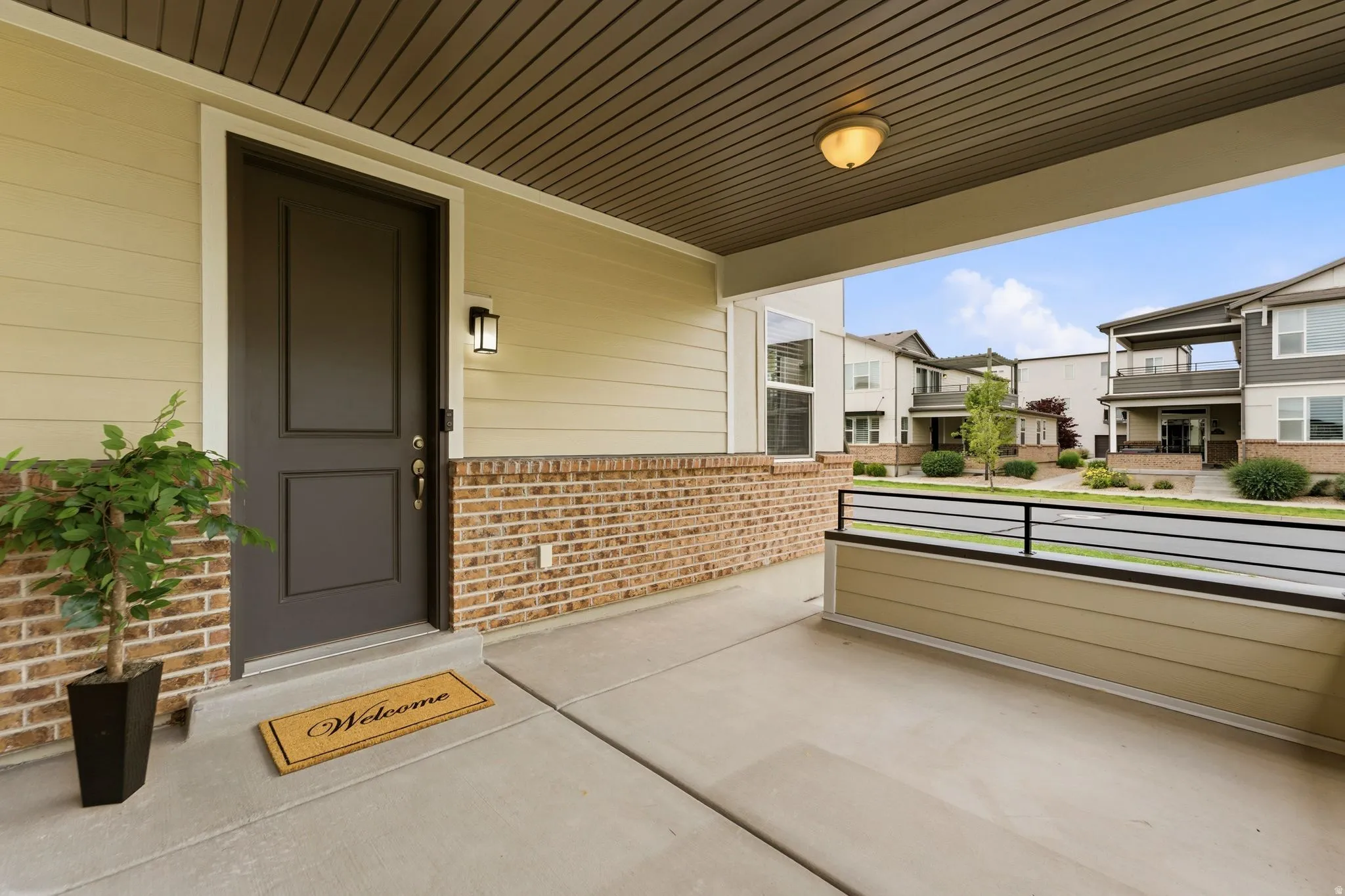 Front porch with concrete flooring and a dark panel door