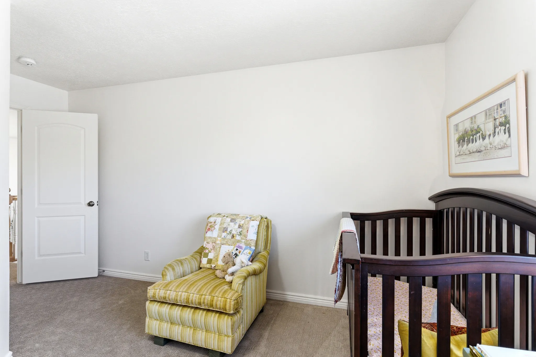 Neutral-toned room featuring light-colored walls and soft carpeting