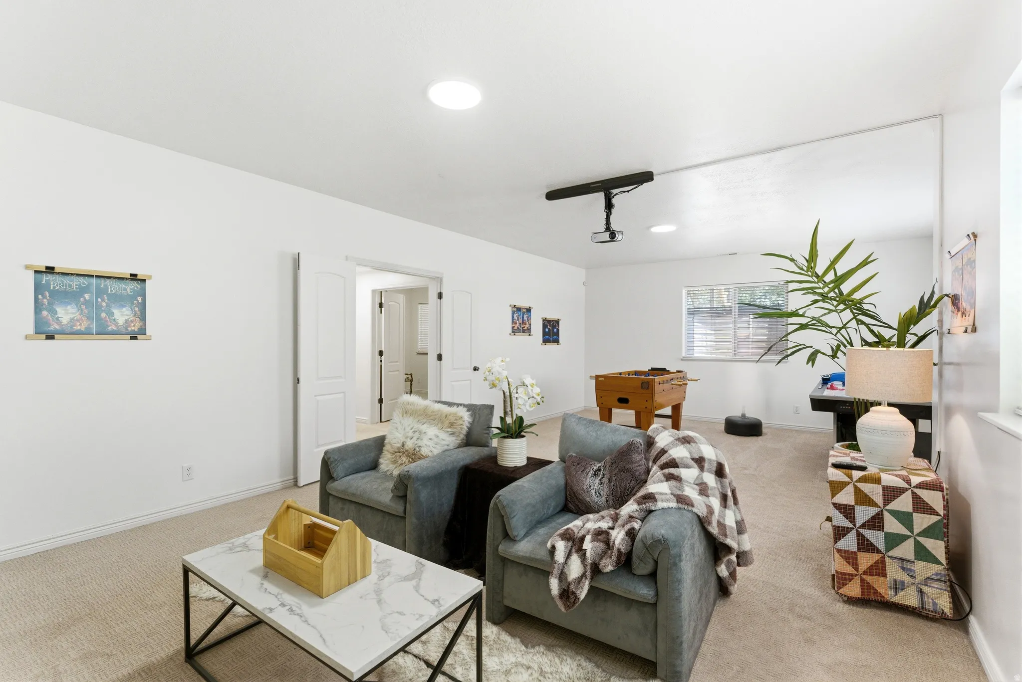 Spacious interior featuring neutral carpet flooring, recessed lighting, and a built-in projector with a screen