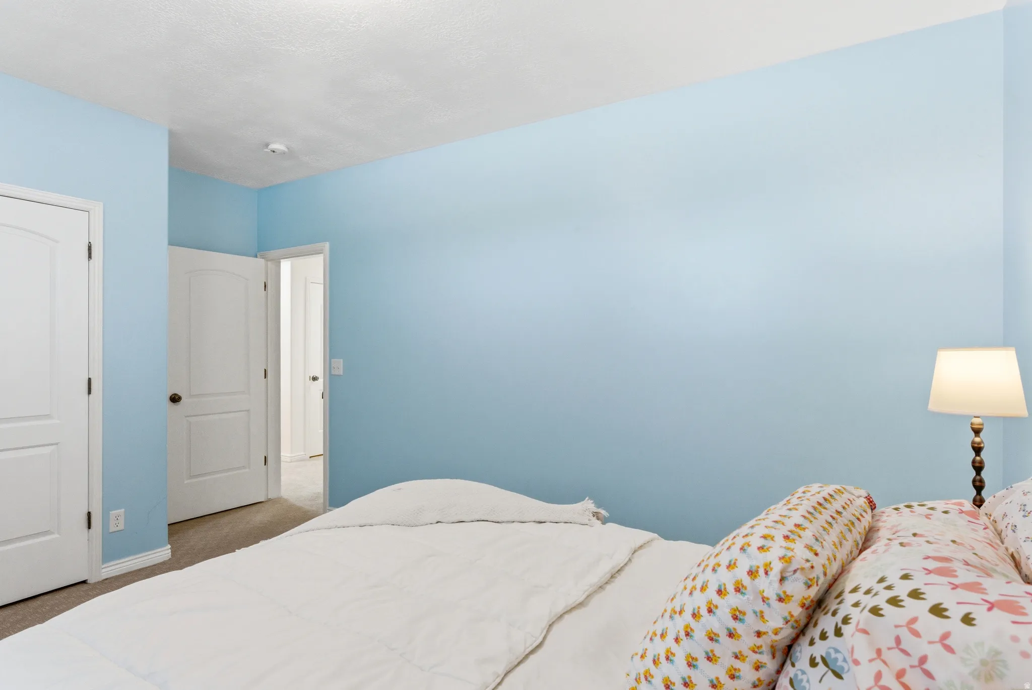 Room featuring light blue walls and neutral carpet flooring