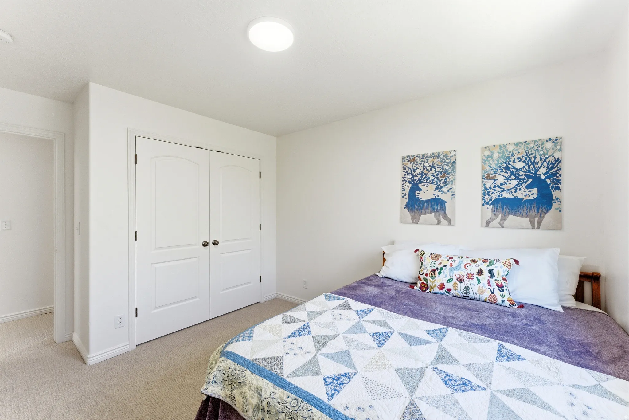Neutral wall paint, recessed lighting, and a double-door closet with arched paneling and dark hardware