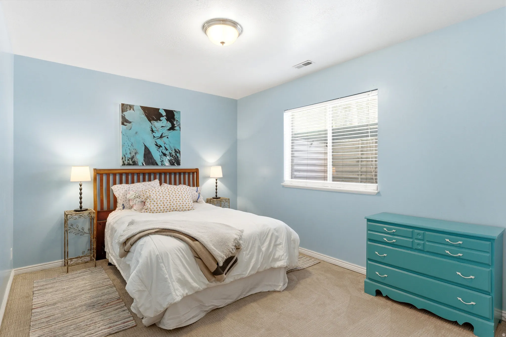 Bedroom featuring light blue walls and neutral carpet flooring