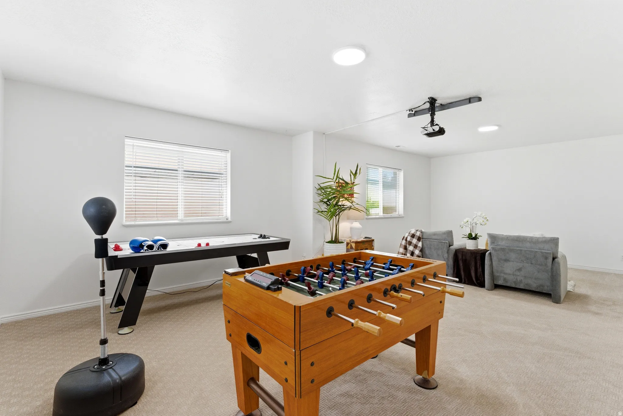 Spacious room featuring neutral carpet flooring, recessed ceiling lighting, and multiple windows with blinds