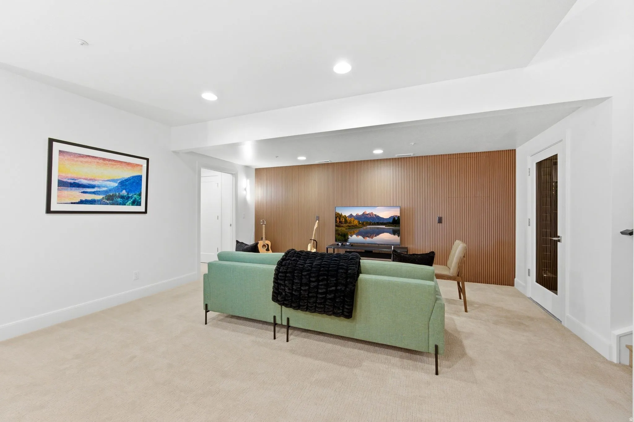 Spacious room featuring light-colored carpeting, recessed lighting, and white baseboards