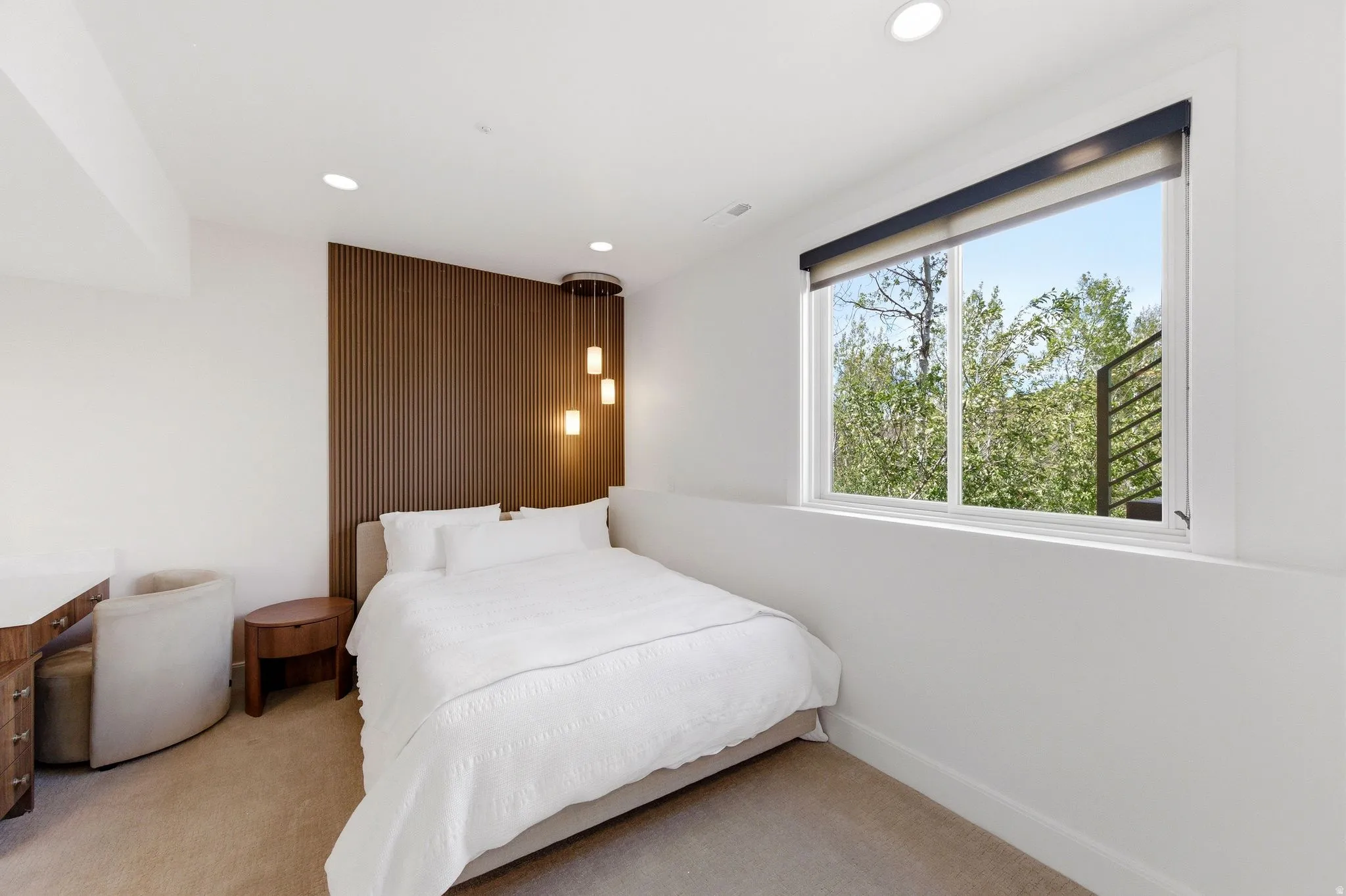 Bedroom featuring a large window, recessed lighting, and a wood-finish accent wall