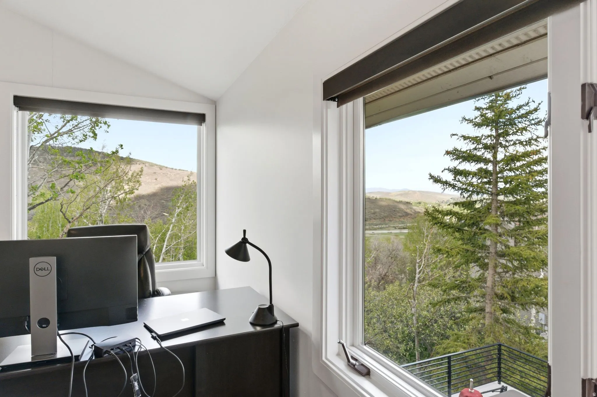 Bright interior space featuring multiple windows with natural light and expansive mountain scenery