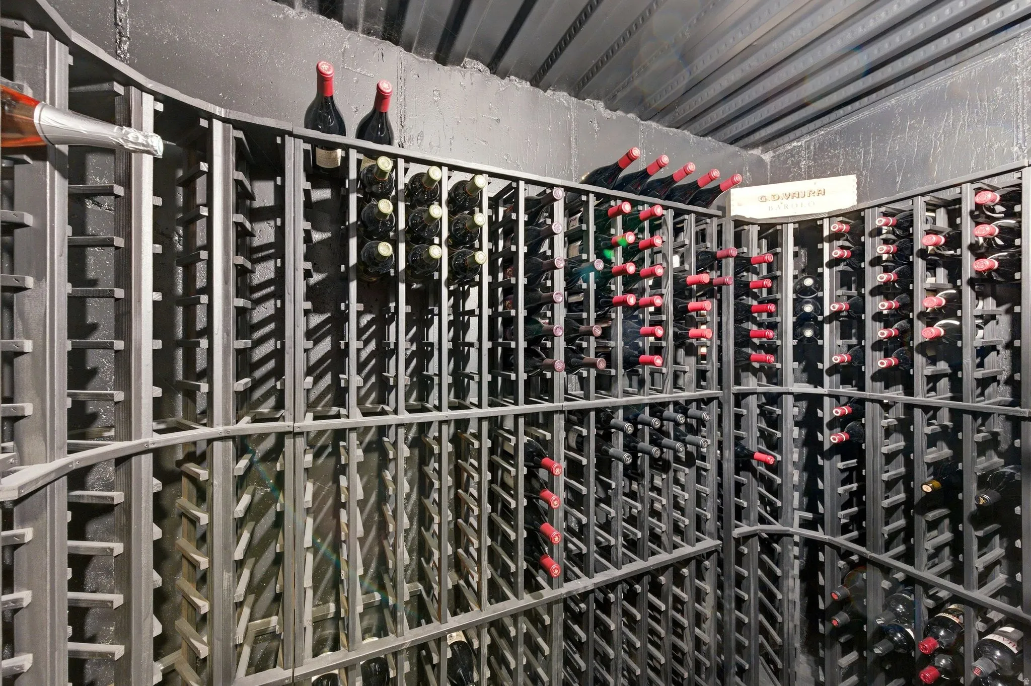Dedicated wine cellar featuring extensive metal racking, curved shelving, and capacity for numerous bottles