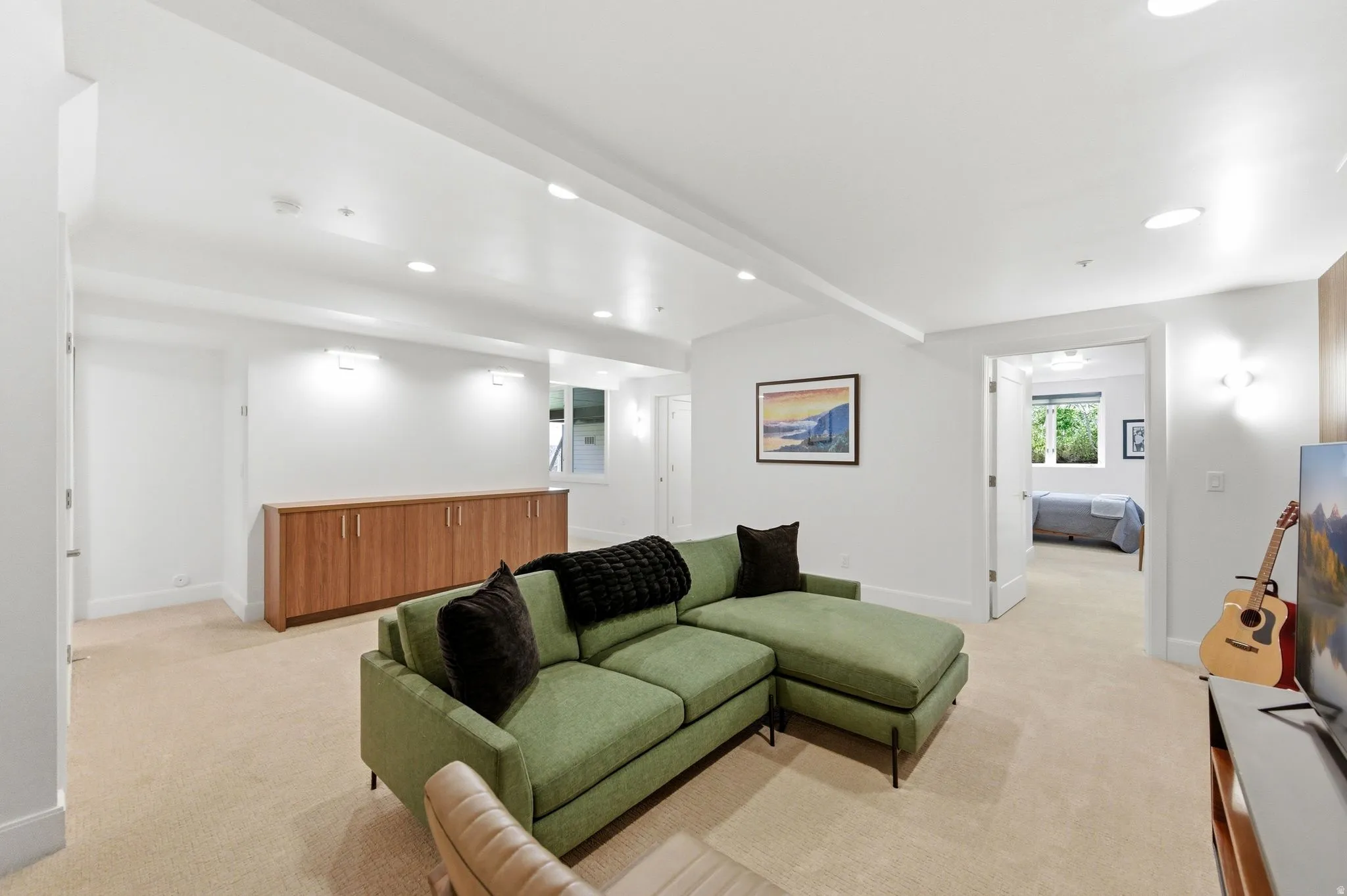 Open-concept recreation area featuring recessed lighting, light-toned carpeting, and a built-in wood-finish credenza