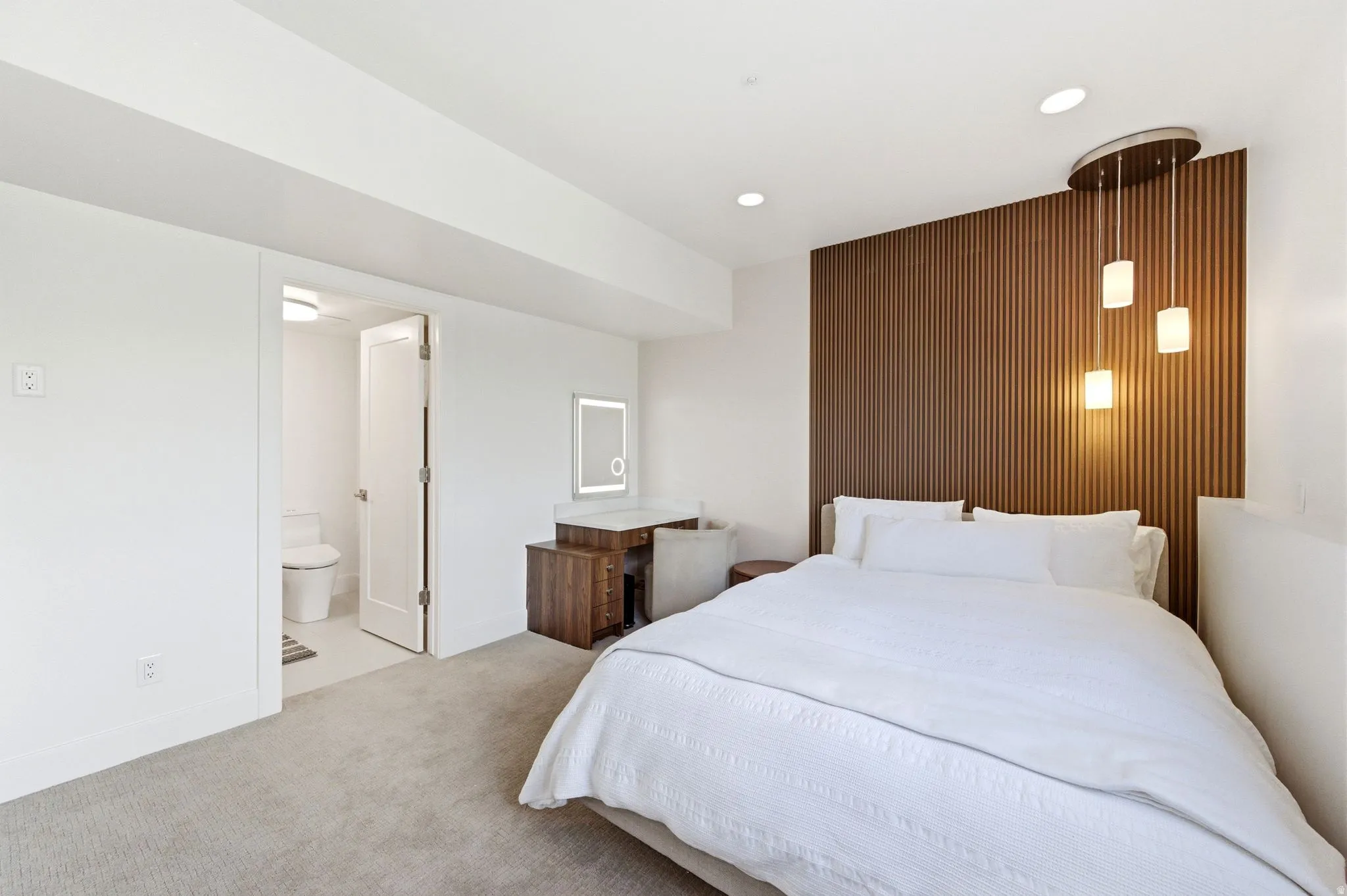 Bedroom with a modern wood-slat accent wall, recessed lighting, and a triple pendant light fixture