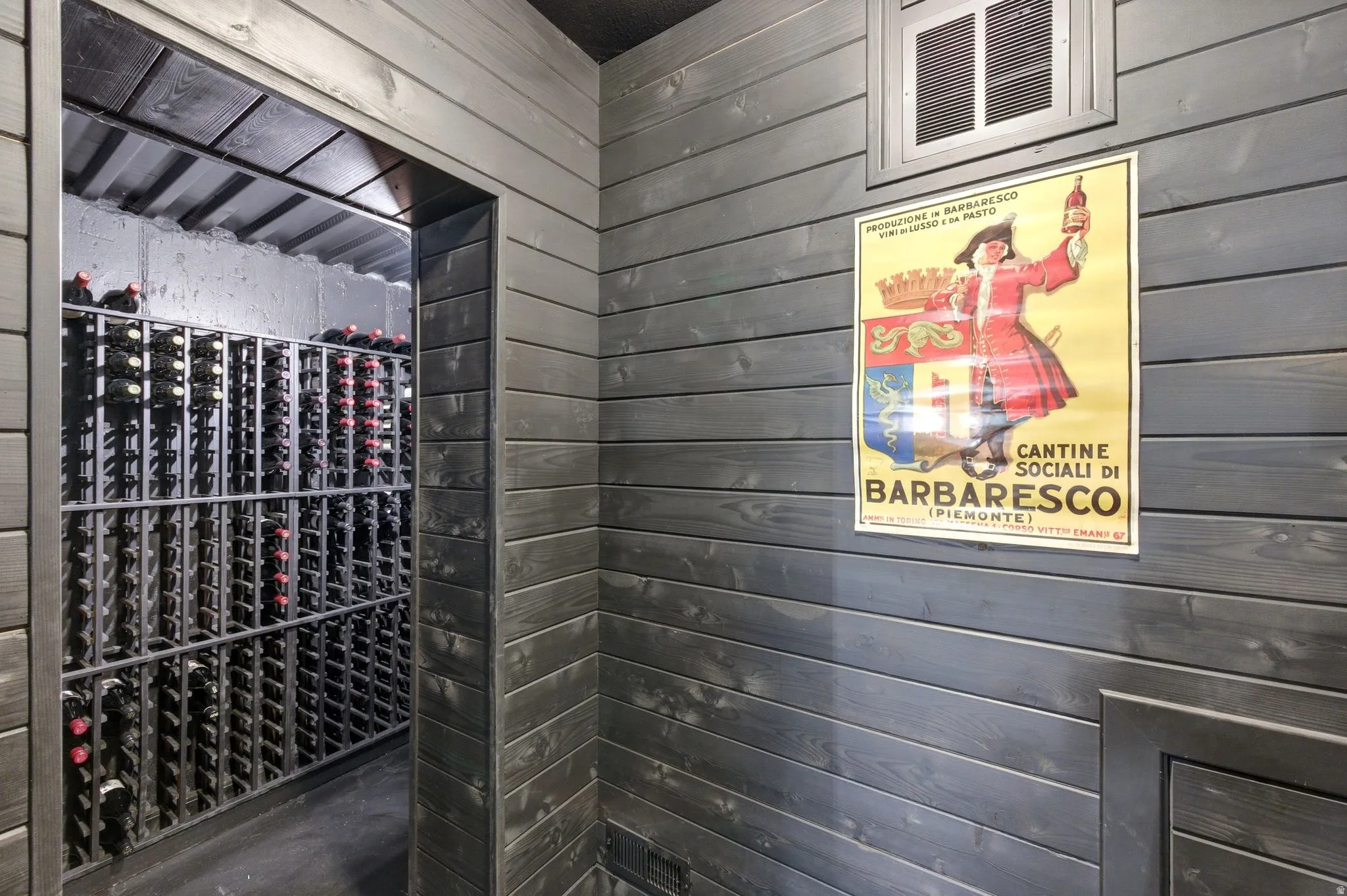 Dedicated wine cellar with extensive metal racking, concrete flooring, and dark wood-finish paneling