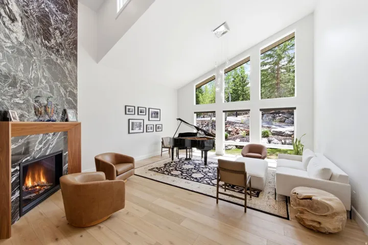 Living area featuring a floor-to-ceiling fireplace with a dark stone surround and wood mantel