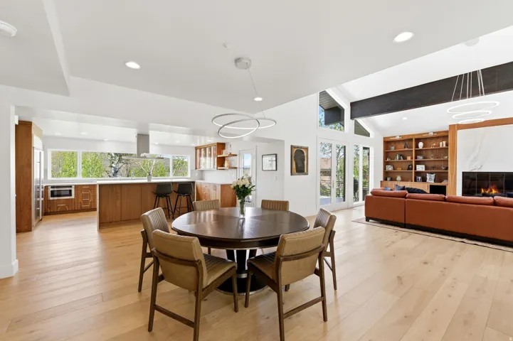 Open-concept living space featuring wood-finish flooring, recessed lighting, and a vaulted ceiling with exposed beams