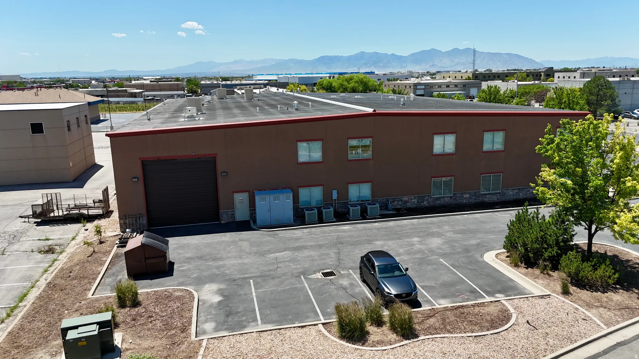 Commercial building featuring a flat roof and brown stucco exterior with a stone veneer accent