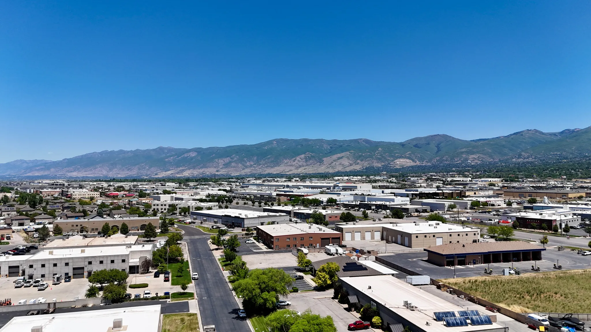 Expansive aerial showcasing a commercial district with a prominent mountain backdrop