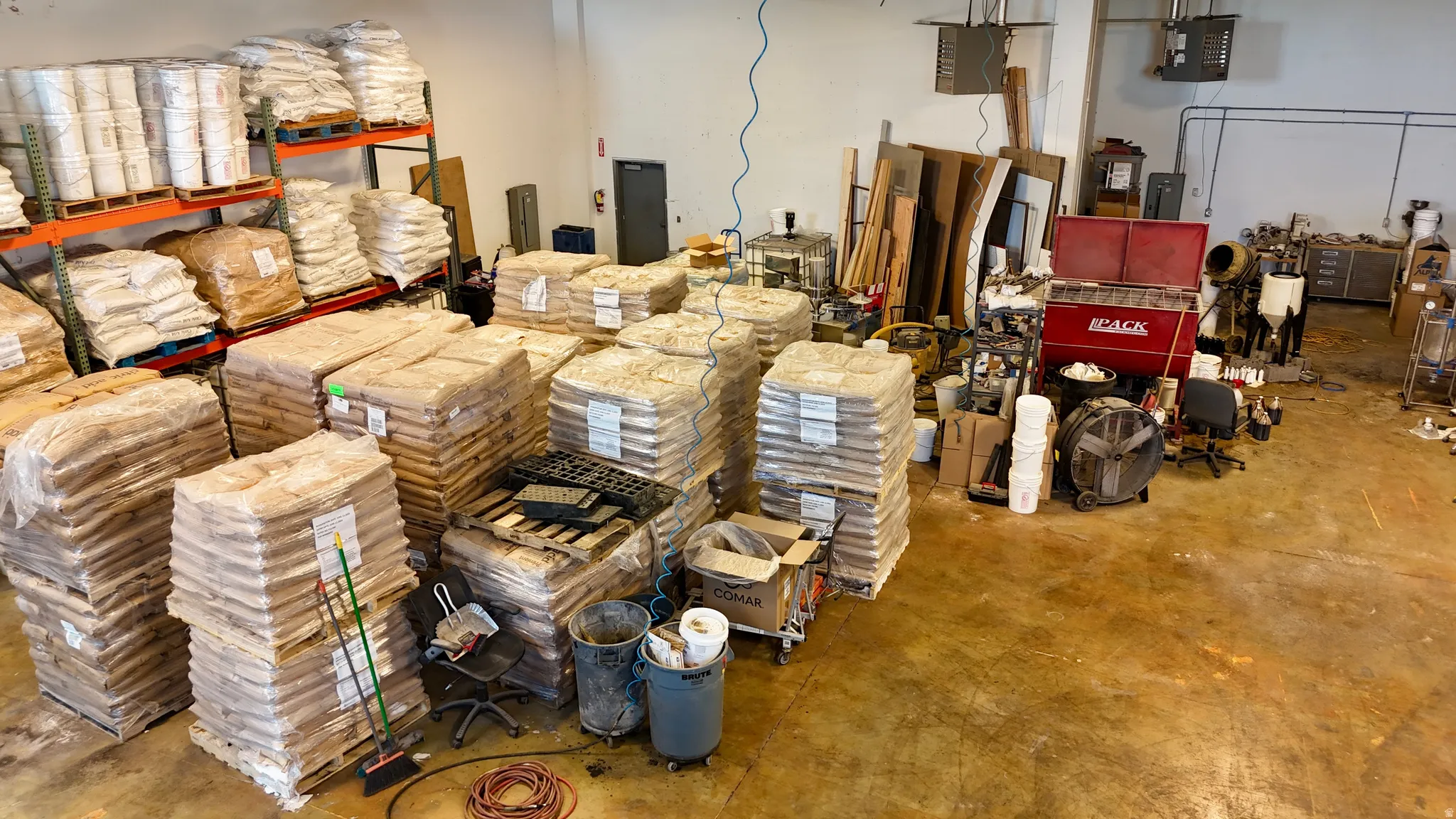 Industrial warehouse space featuring high ceilings, concrete flooring, and extensive pallet racking