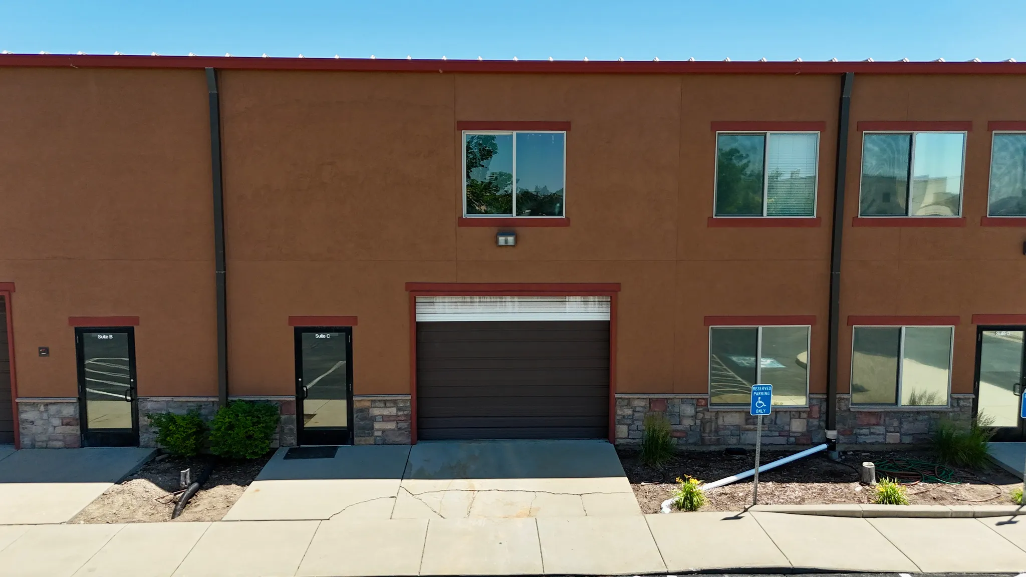 Commercial building exterior featuring a stucco finish with stone veneer accents