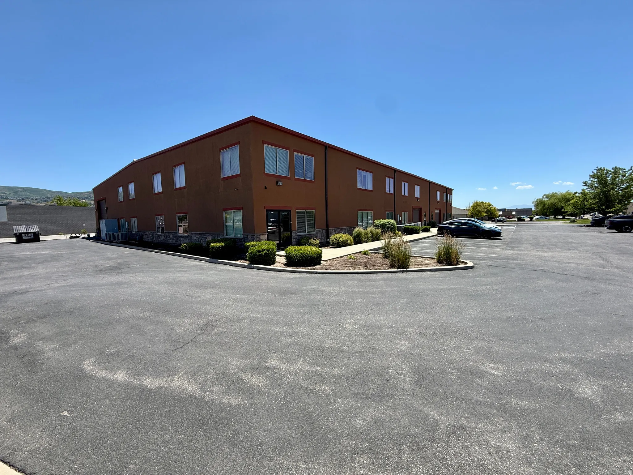 Two-story commercial building featuring a brown stucco facade with stone detailing