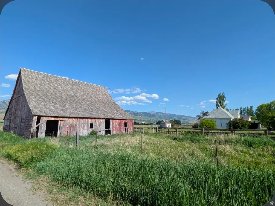 Red-sided barn with a gabled roof and open bays