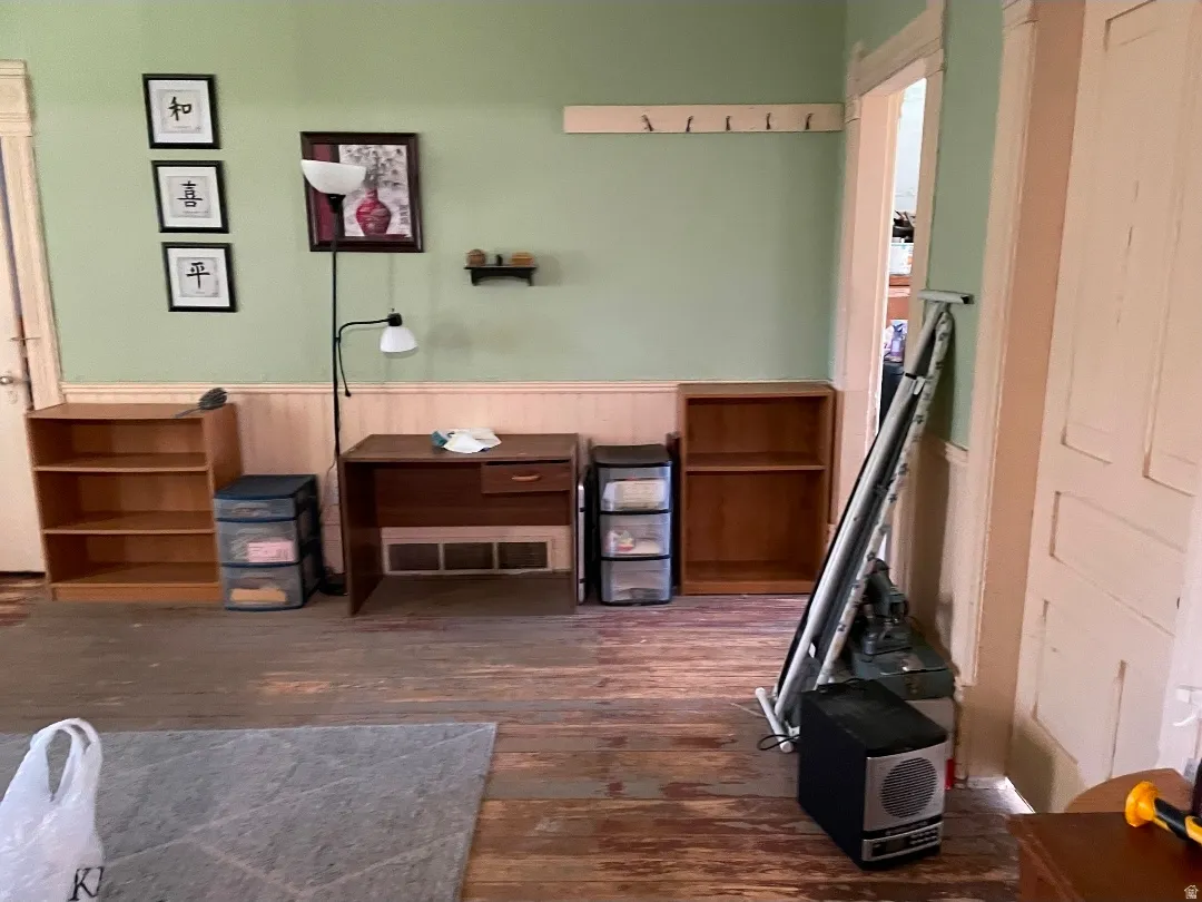 Hardwood flooring with a distressed finish, featuring light green walls and white wainscoting