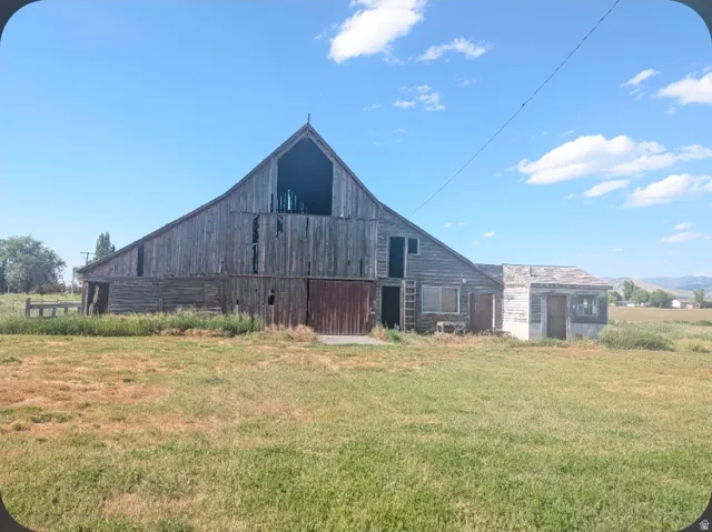 Rustic barn structure with weathered wood siding, including a peaked gable roof and a smaller attached outbuilding
