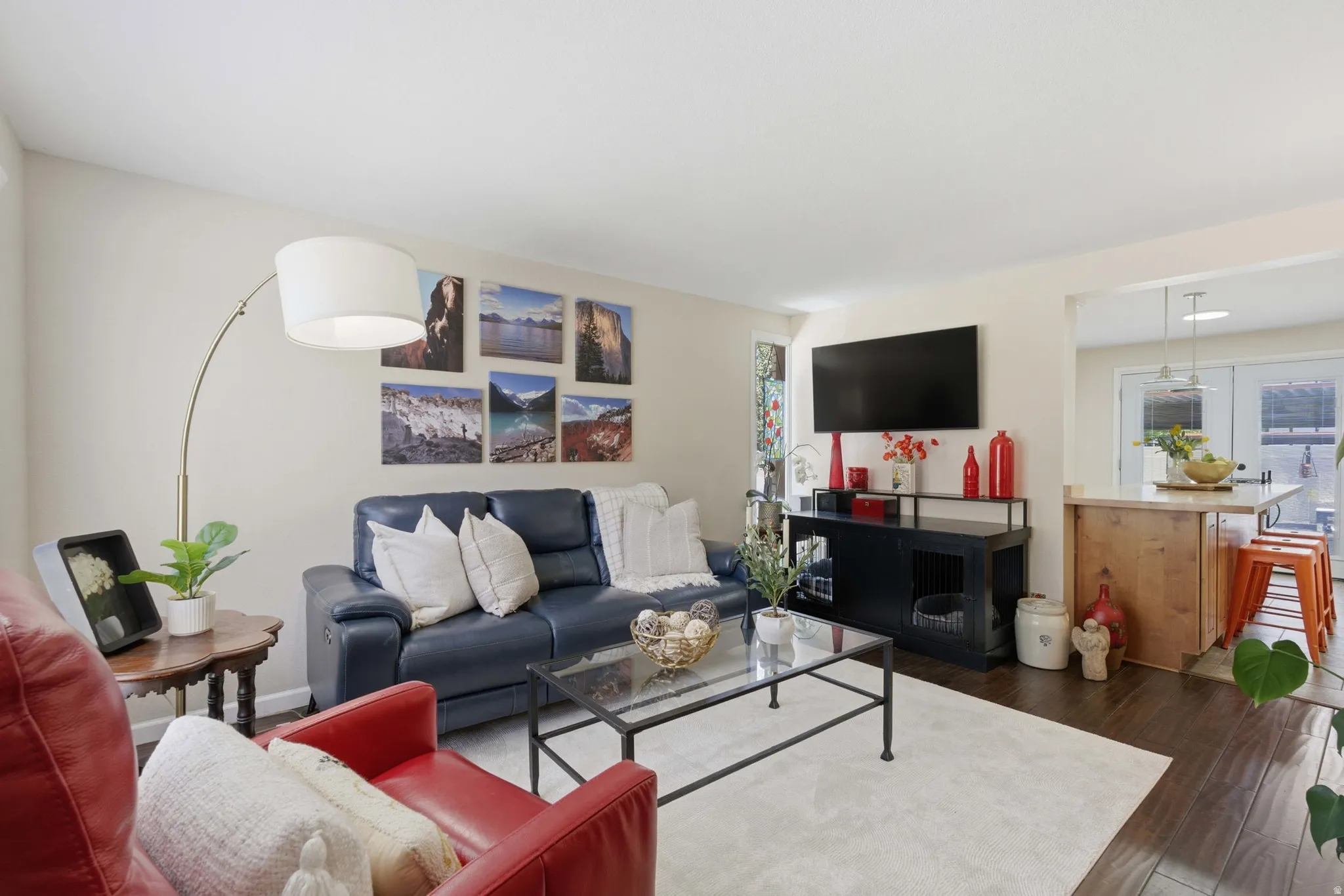 Living area featuring wood flooring, a neutral color palette, and an open concept layout with a kitchen pass-through