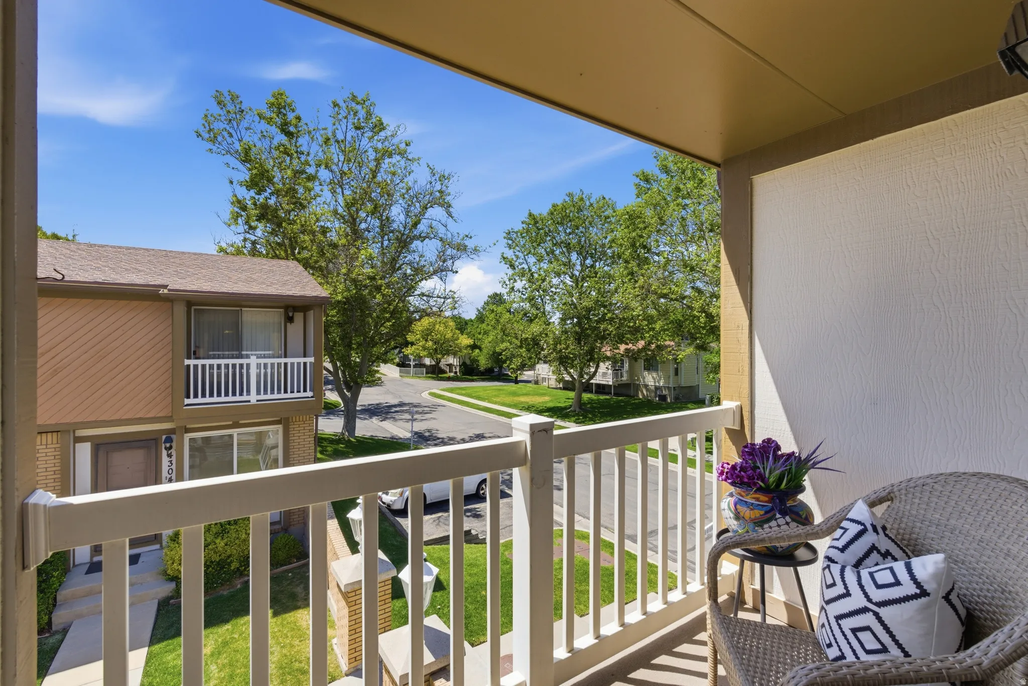 Private balcony featuring a white railing and textured exterior wall