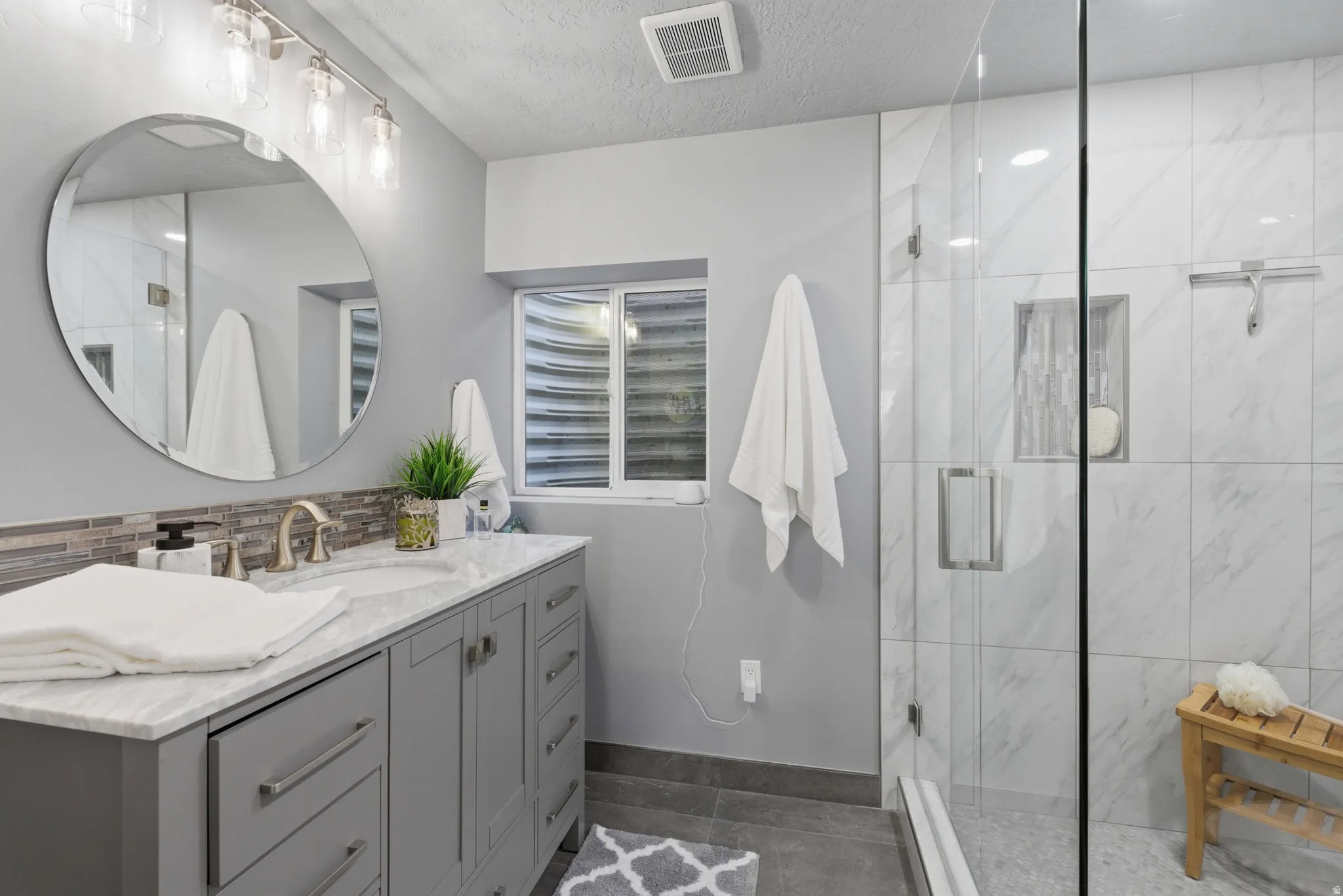 Contemporary primary bathroom featuring a spacious glass-enclosed shower with tiled walls and a built-in niche