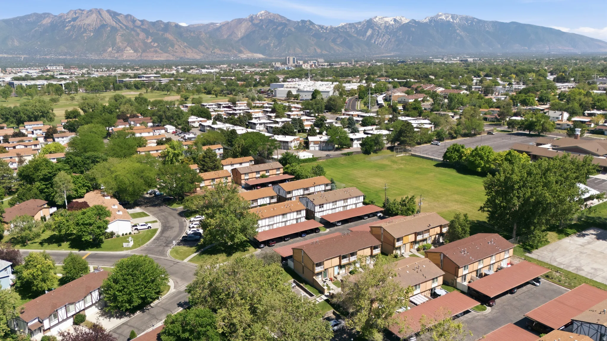 Aerial perspective showcasing a residential community with abundant green spaces and mature trees