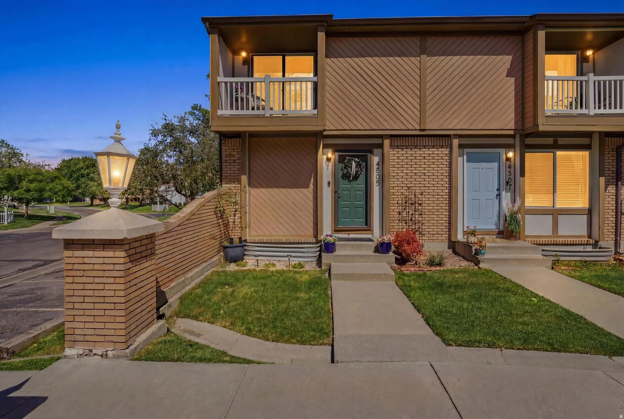 Townhome exterior featuring brick and wood-paneled siding