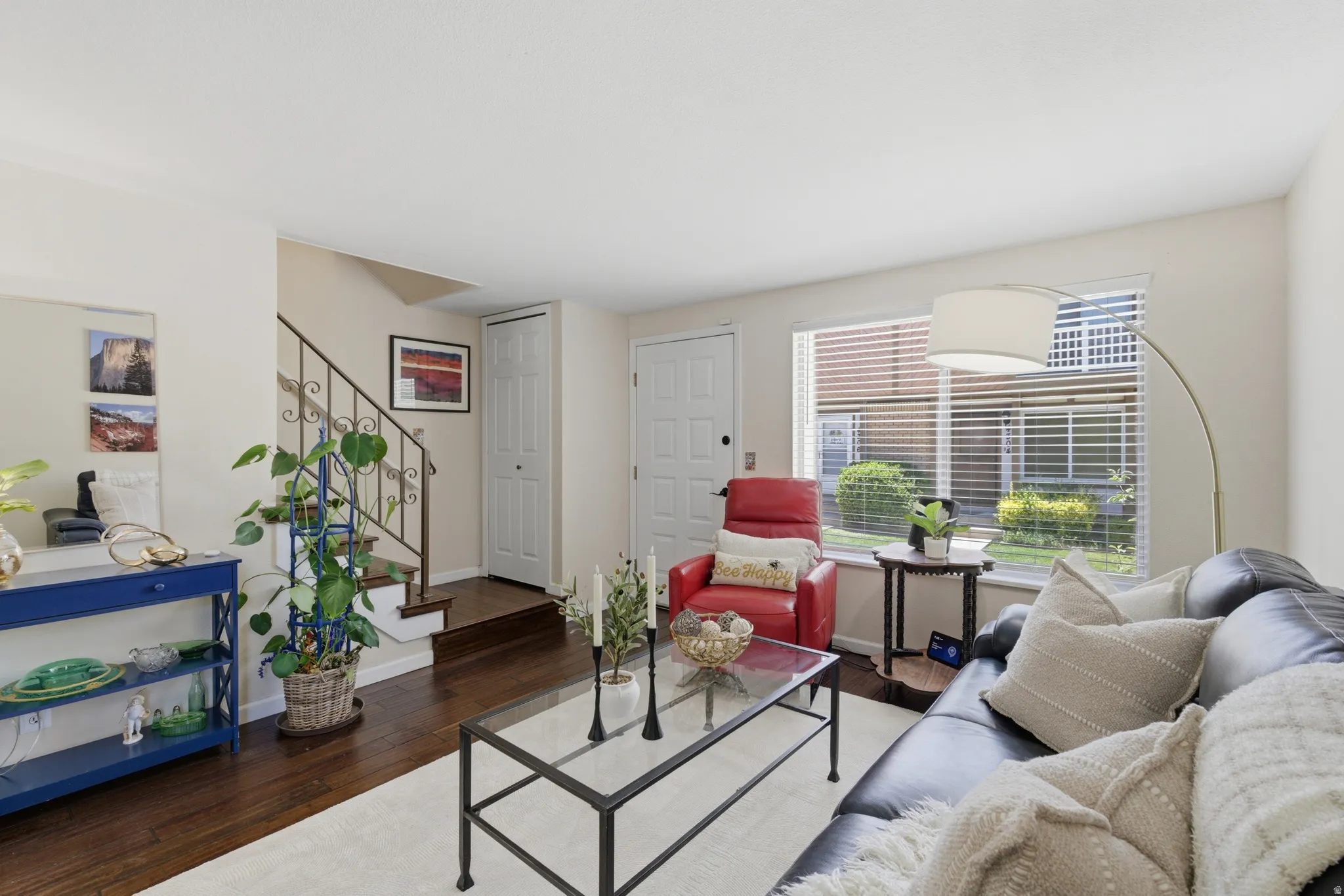 Hardwood flooring extends throughout this living area, featuring a decorative wrought-iron staircase railing