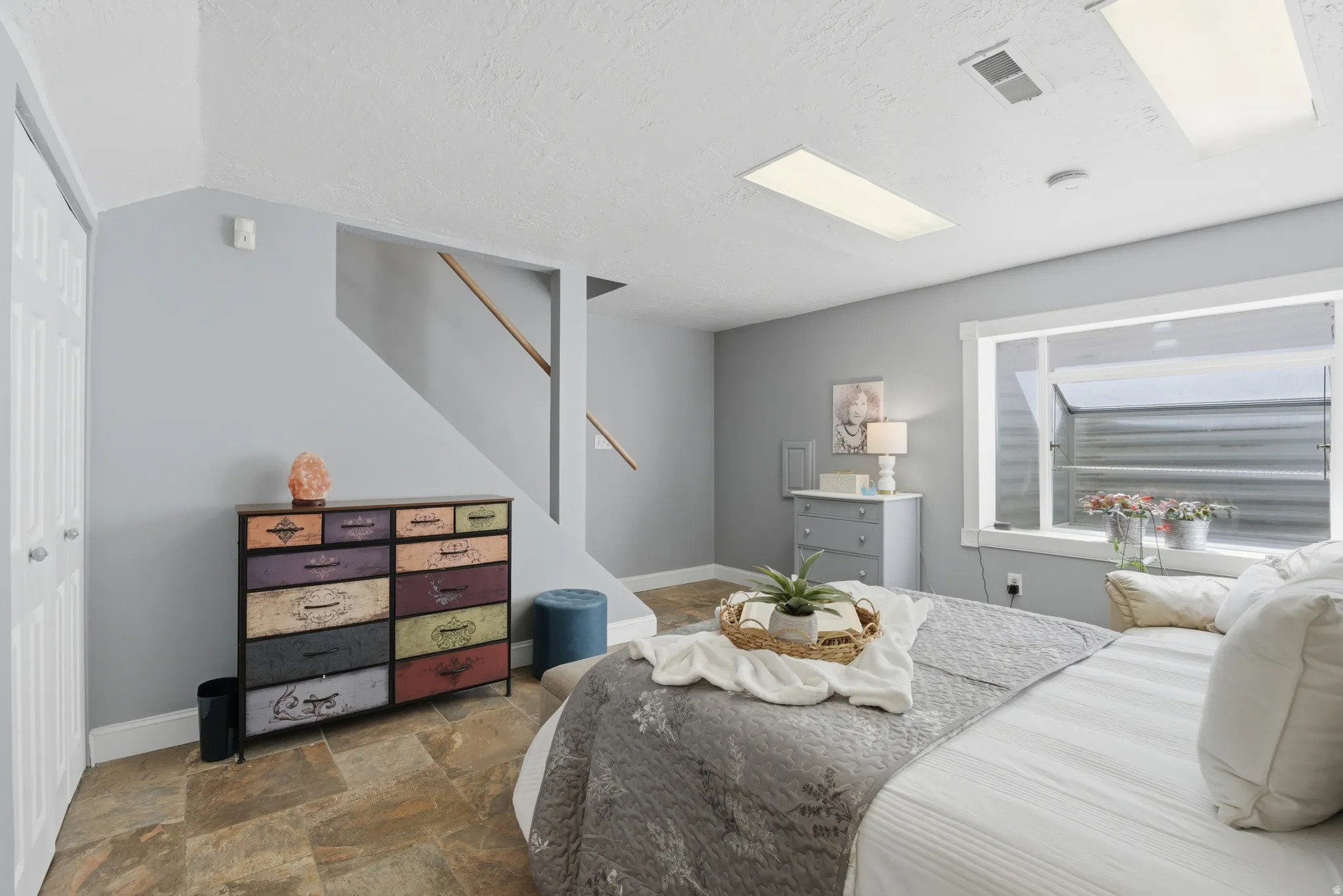 Spacious primary bedroom featuring neutral wall tones, recessed lighting, and durable tile flooring