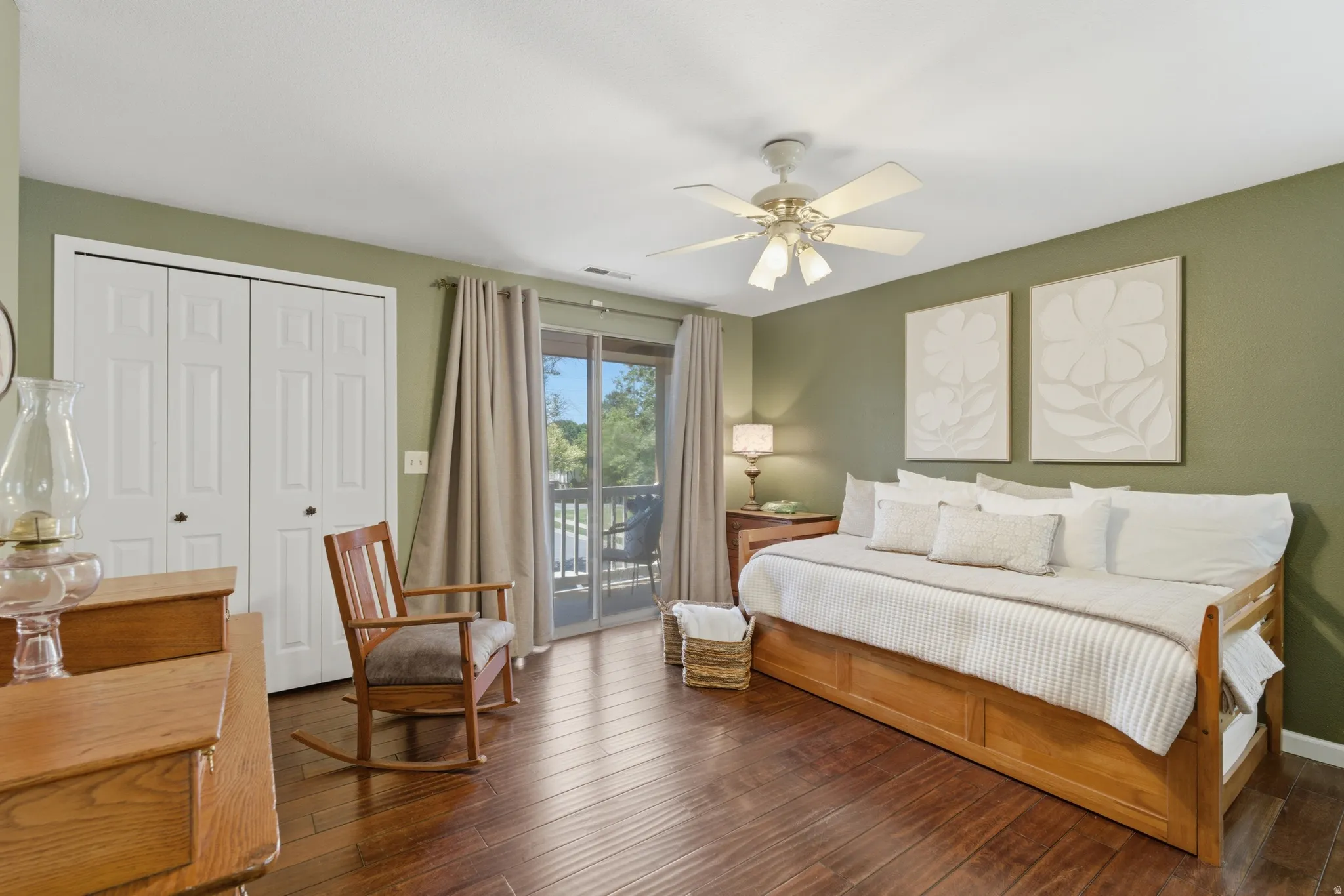 Room featuring wood flooring, a ceiling fan with integrated lighting, and a sliding glass door providing balcony access