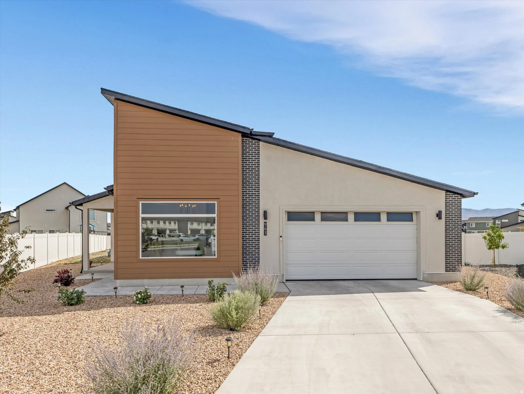 Contemporary exterior featuring a single-car garage, stucco siding, and stone accents