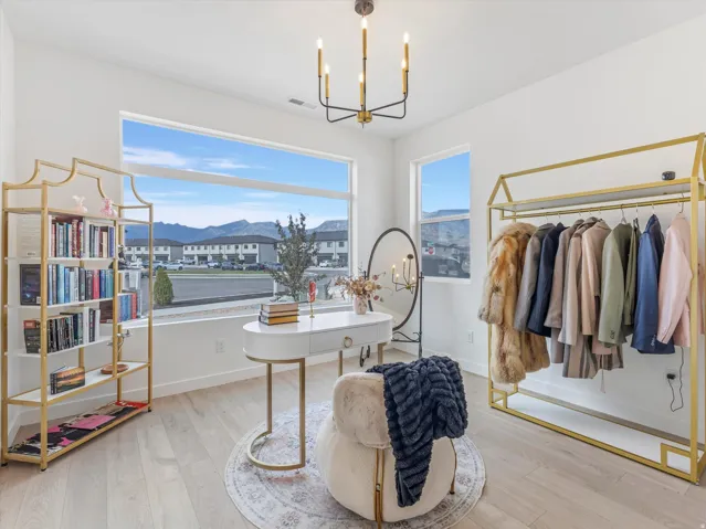 Spacious interior featuring wood-finish flooring, a contemporary chandelier, and large windows