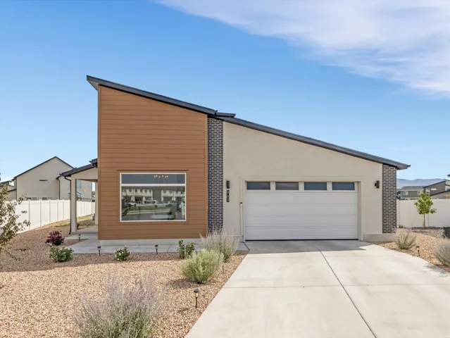 Contemporary exterior featuring a single-car garage, stucco siding, and stone accents
