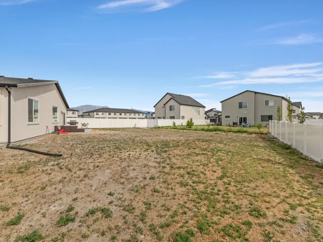 Expansive lot featuring a large open area, perimeter fencing, and a mountain backdrop