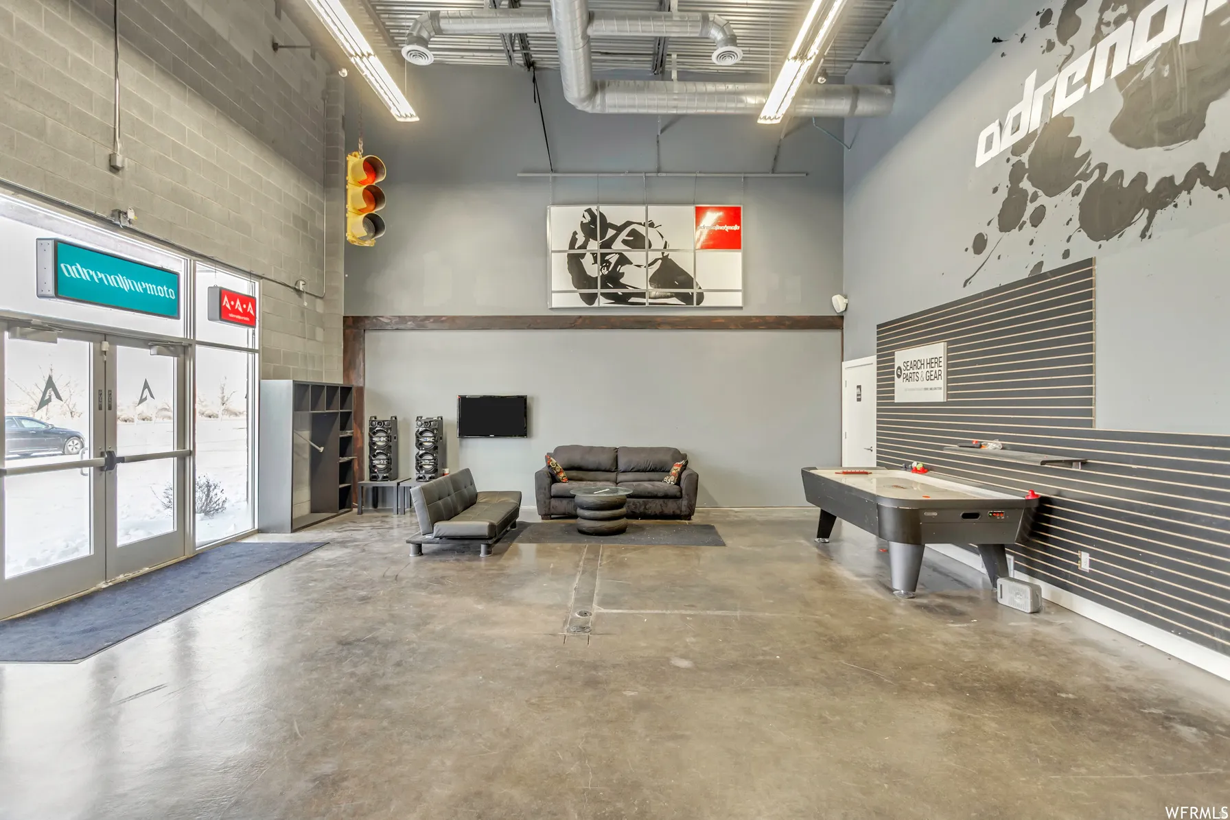 Spacious interior featuring a concrete floor, high exposed ceilings, and a light gray wall finish