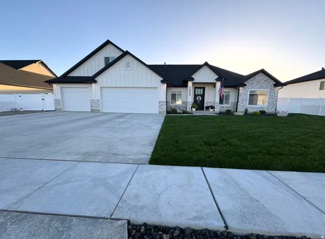 Contemporary ranch-style residence featuring a combination of white board-and-batten siding and stone veneer accents