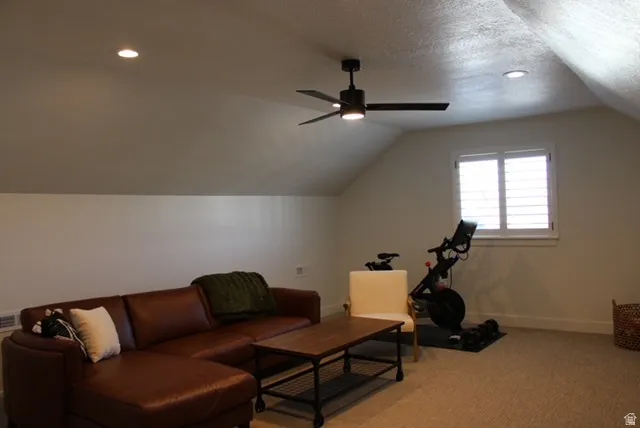 Attic space featuring sloped ceilings, recessed lighting, and a ceiling fan