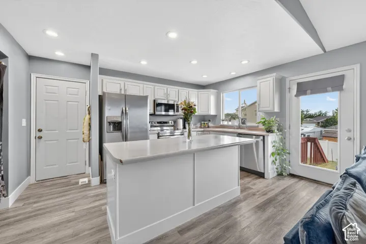 Bright kitchen featuring white cabinetry and a central island with a solid surface countertop