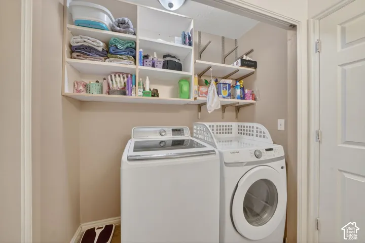 Laundry area featuring built-in shelving, track shelving, and neutral wall paint