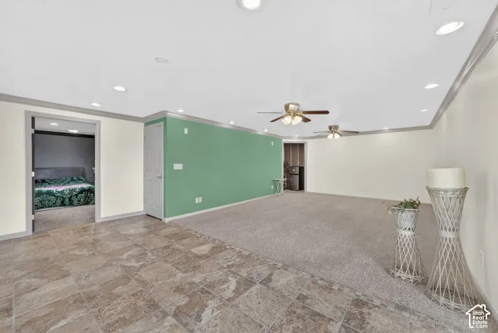 Spacious interior featuring a combination of tiled and carpeted flooring, recessed lighting, and multiple ceiling fans