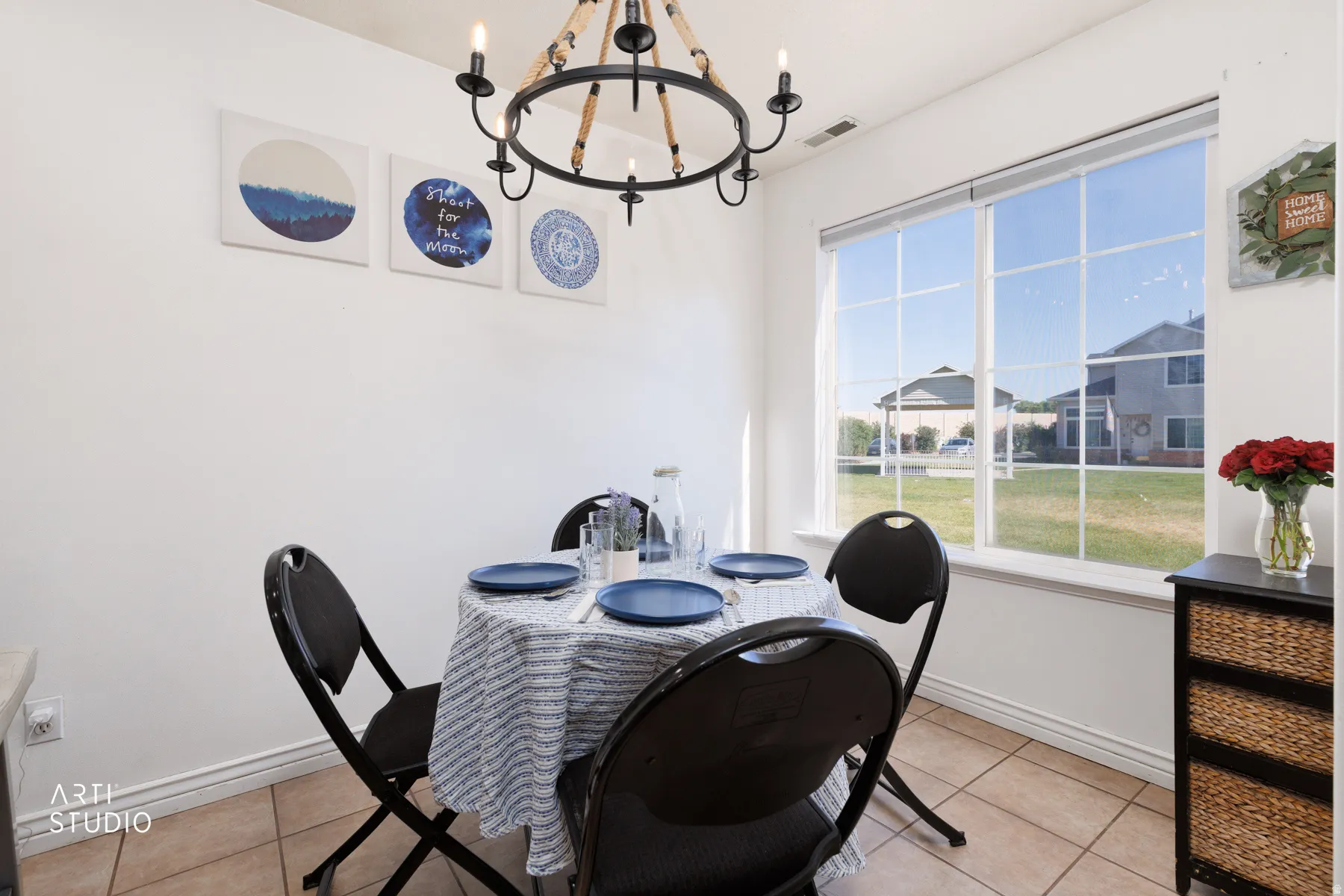 Dining area featuring a prominent window, a circular chandelier, tile flooring, and clean white walls