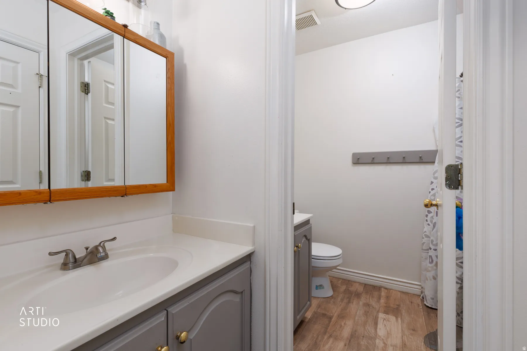 Bathroom vanity featuring a light-toned countertop, integrated sink, and brushed nickel faucet