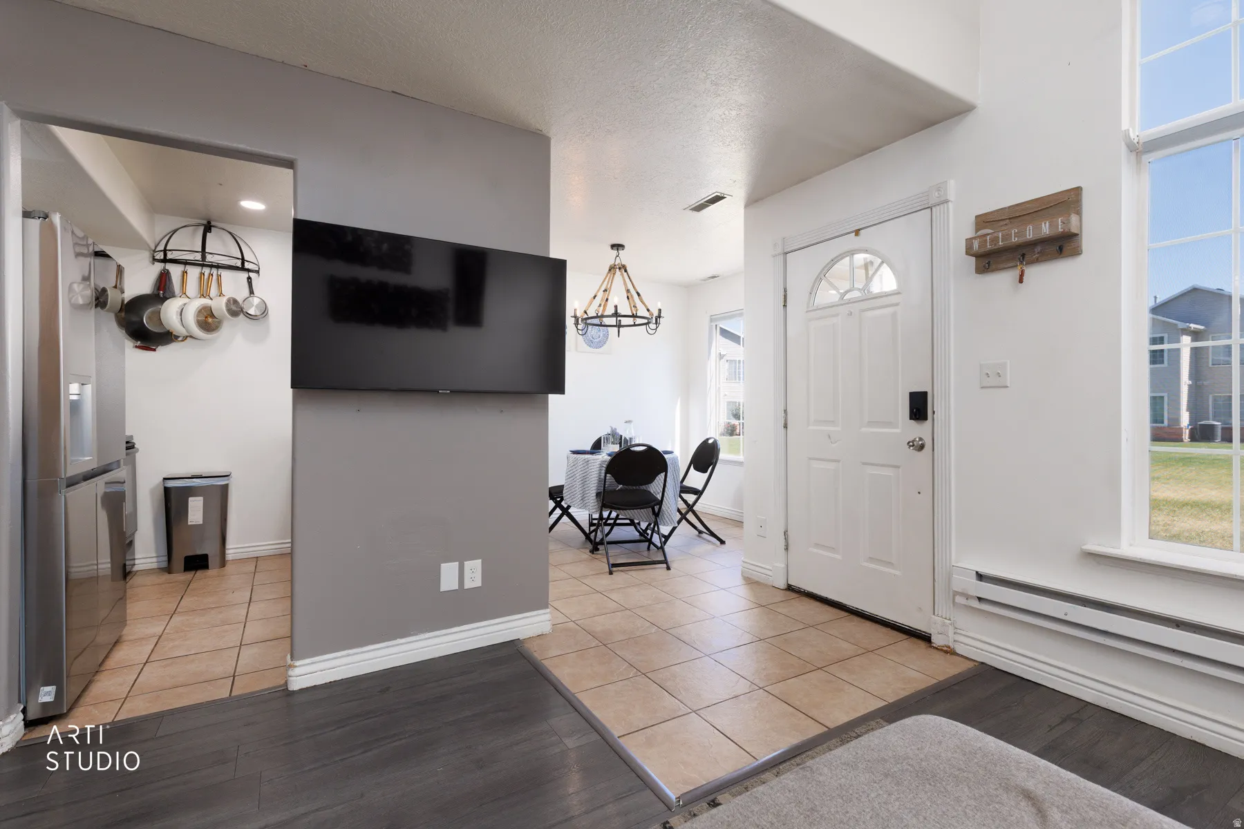 Entryway featuring a white paneled door with an arched window, tile flooring, and high ceilings